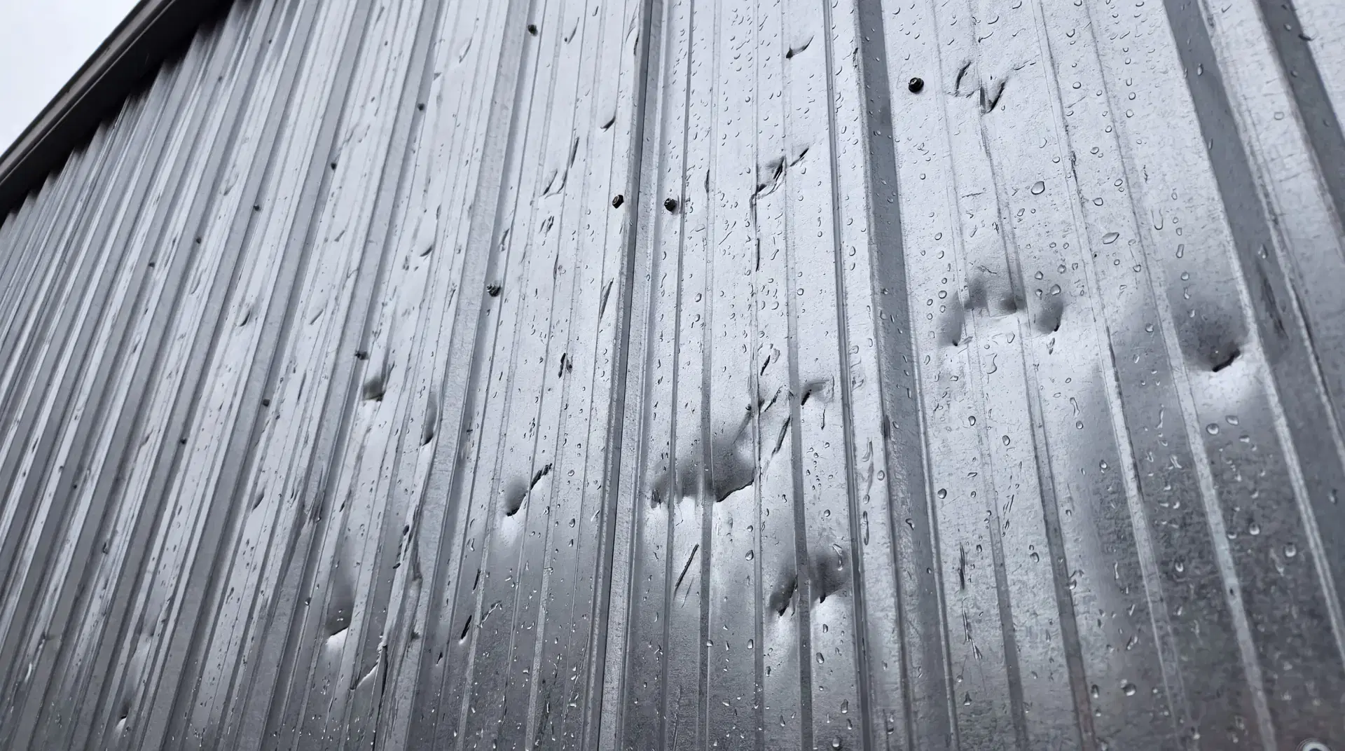 Hail-dented steel siding on a Minnesota pole barn, the kind of storm damage Orton Companies triages