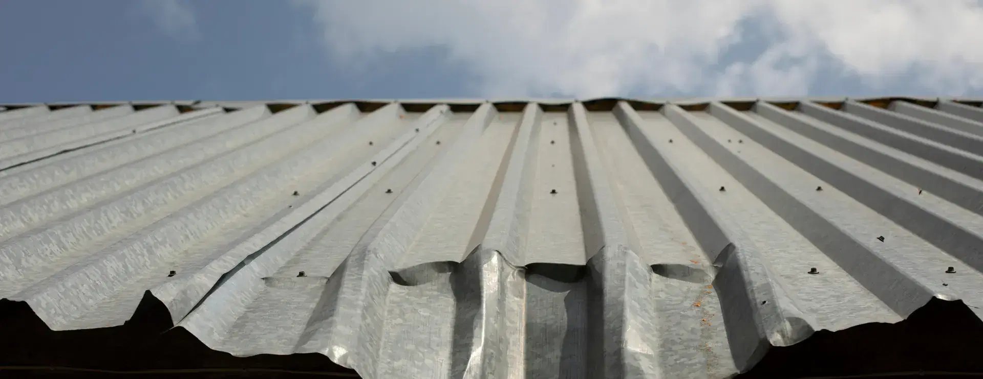 Dented steel roof eave on a Minnesota post-frame building inspected by Orton Companies