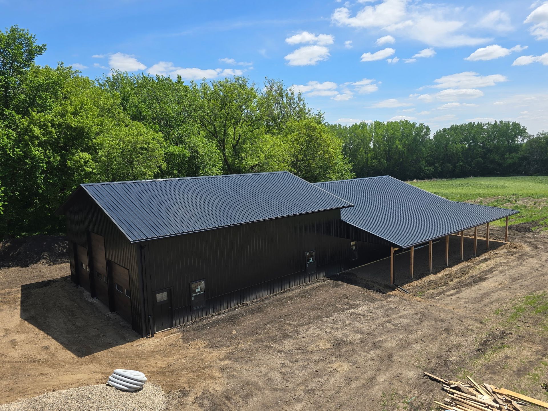 Finished premium pole barn with black metal and tall bay doors