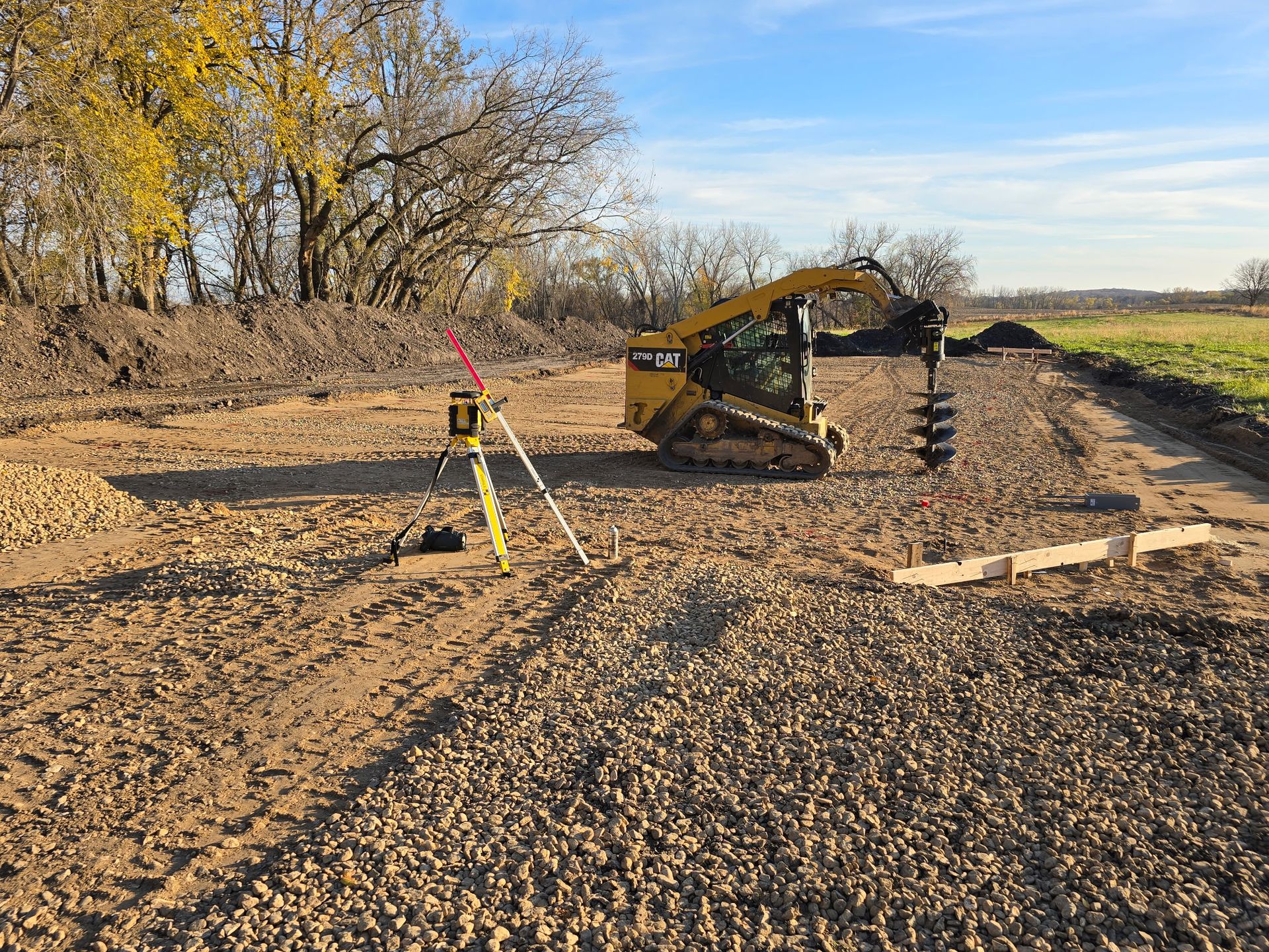 Skid steer leveling the base for pole barn construction