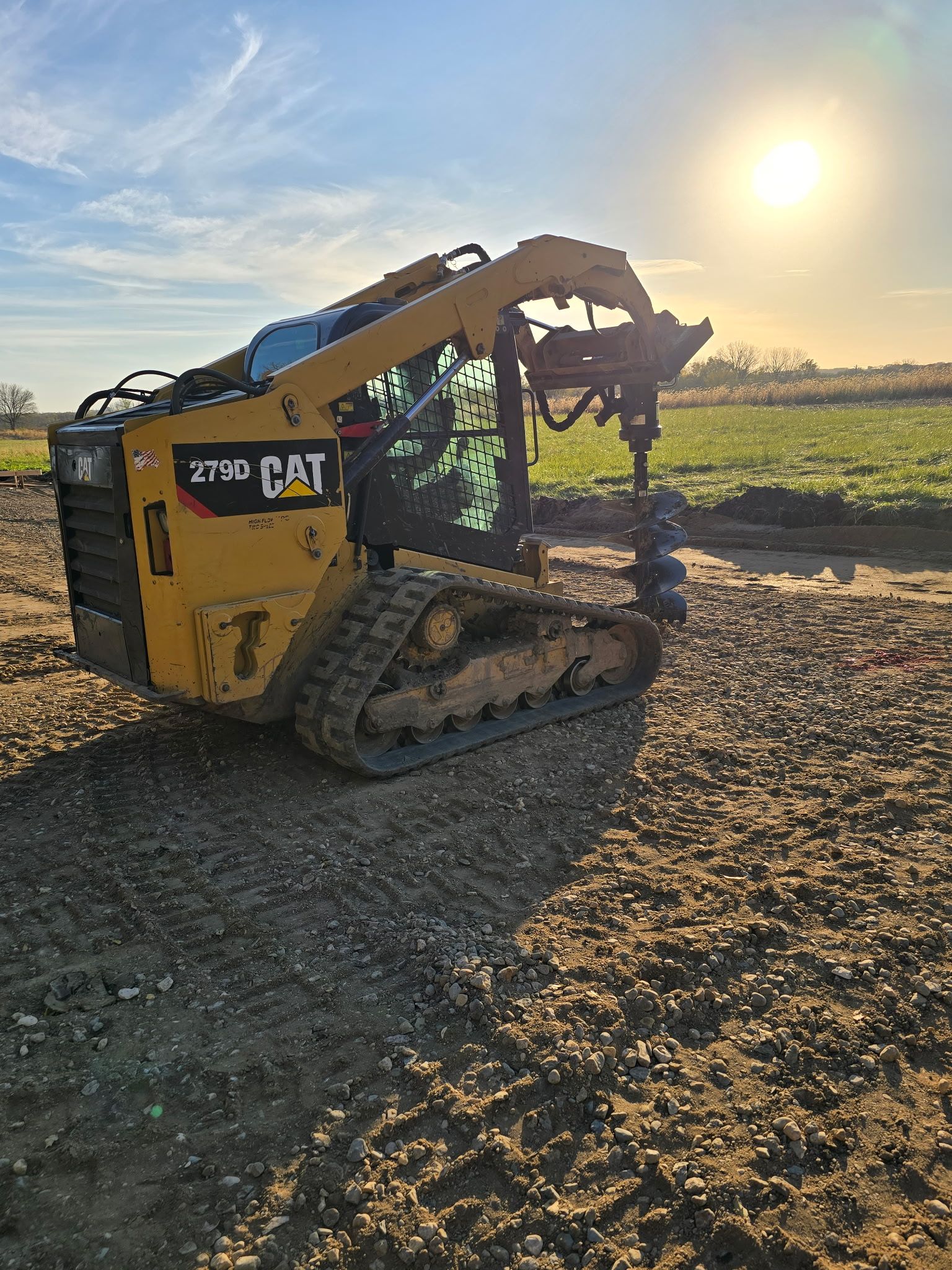 Skid steer assisting with pole barn foundation work
