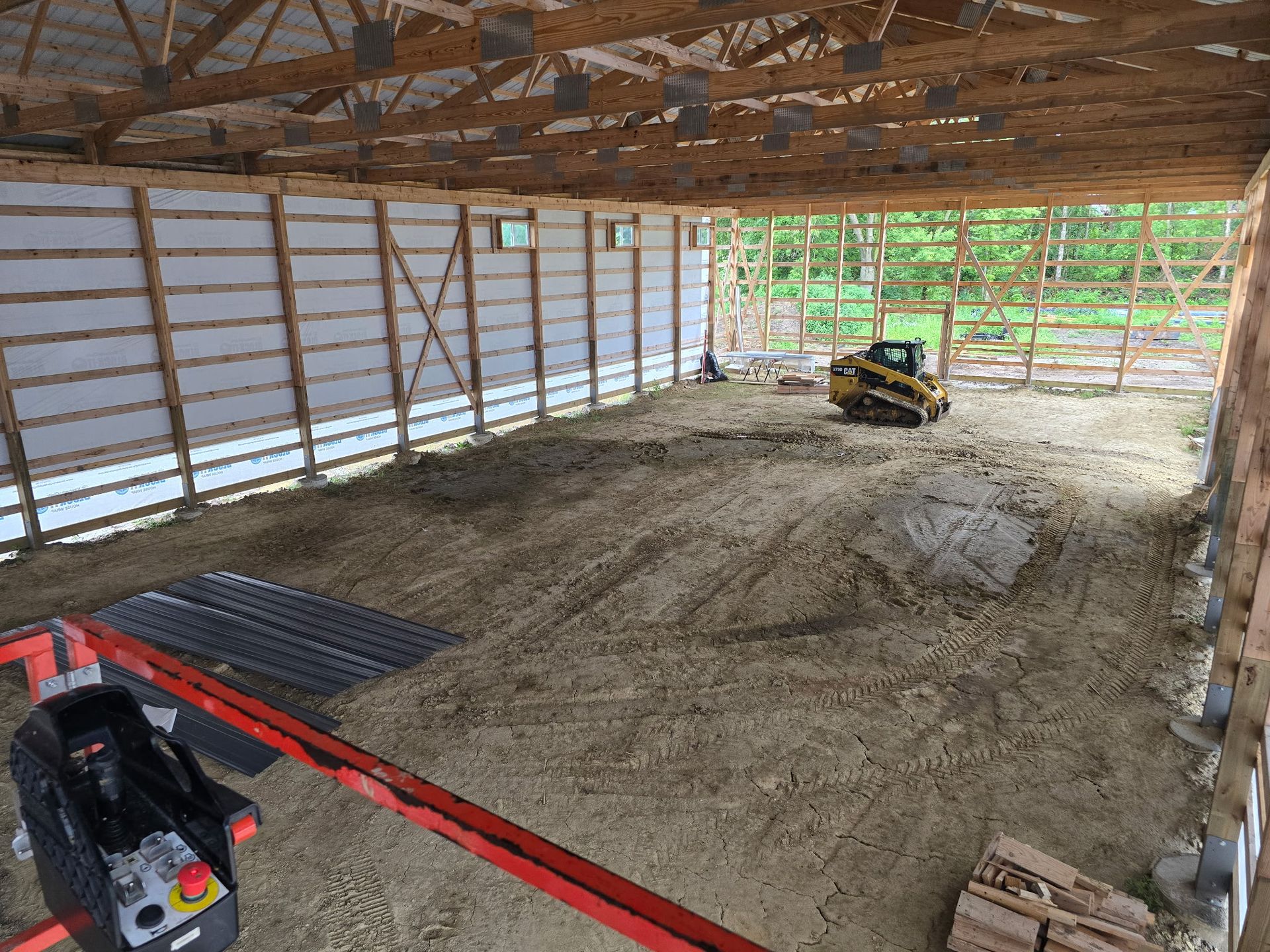 Commercial building interior during framing with skid steer on site